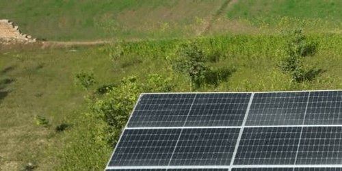 Solar panels on the roof of Rehman Filling Station beside green fields